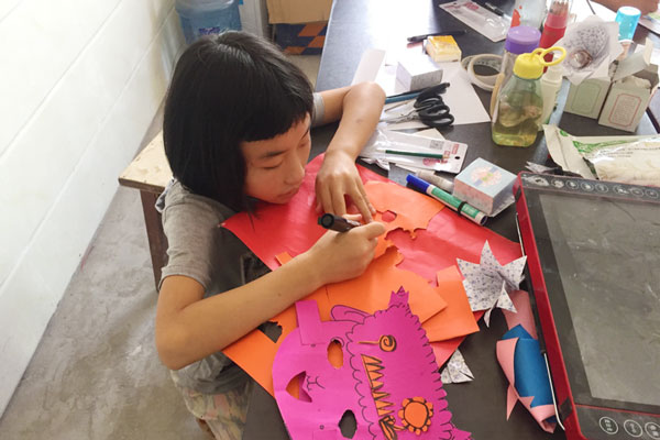上元村的孩子趴在桌上做情景剧道具.jpg